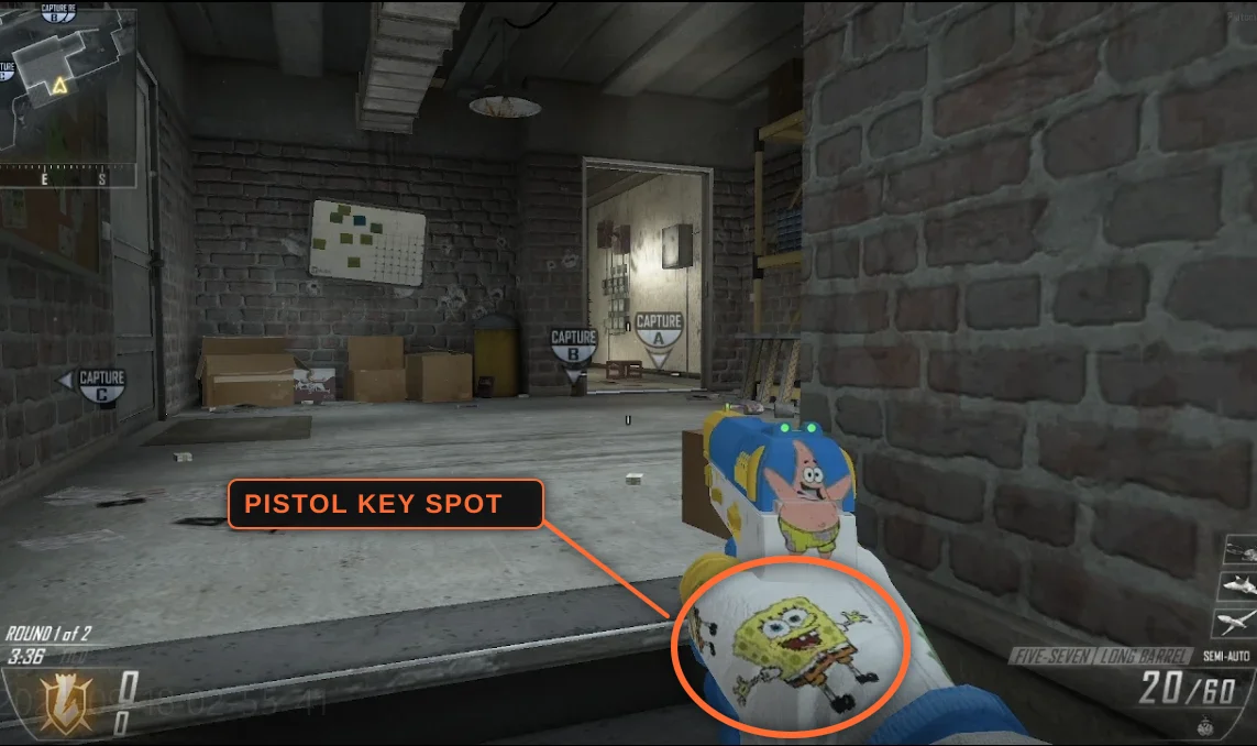 A pistol held in game, with the logo on the back of the glove ringed and labelled as the pistol key spot